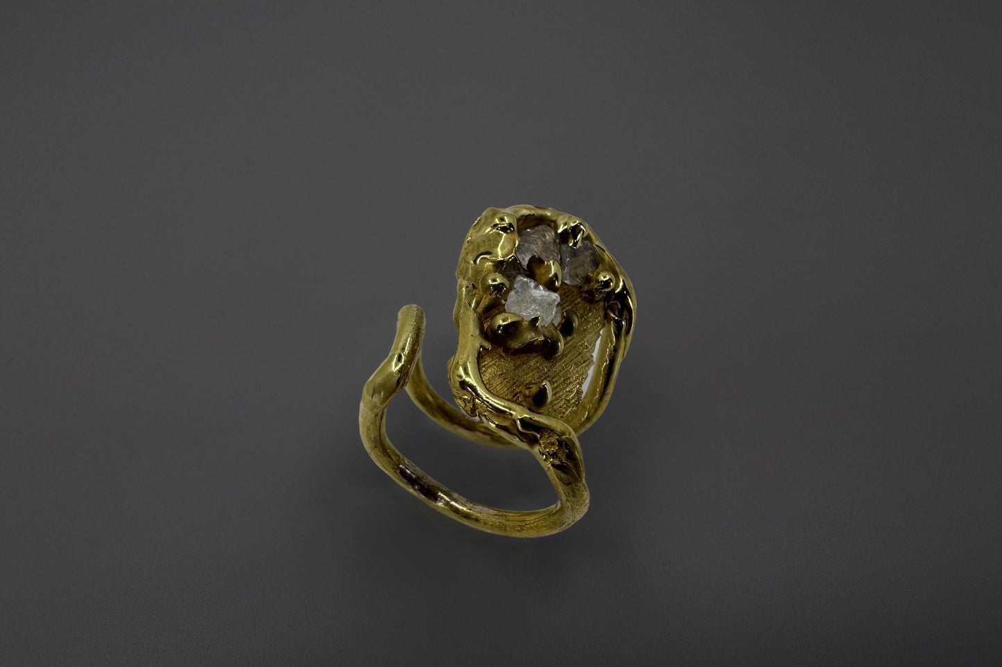 Goldeb brass ring with clear quartz crystals on a dark gray background