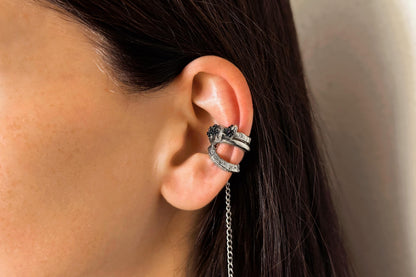 Close-up of an ear with a sterling silver ear cuff with black carborundum stone