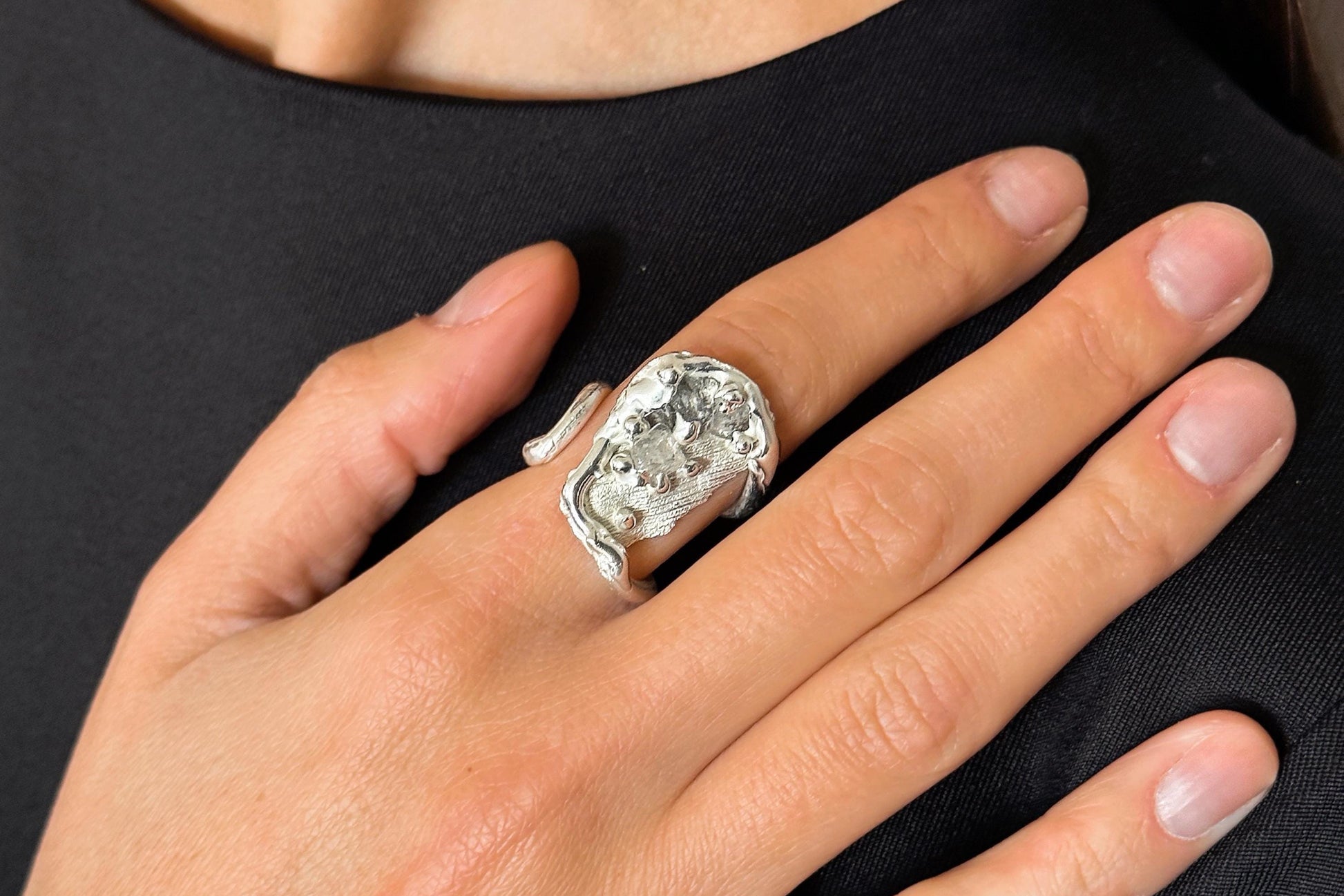 Sterling Silver ring with quartz crystals on a person's finger
